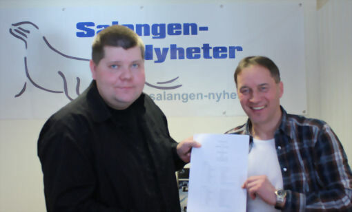 Leder for Millionfisken Kurt Jan Kvernmo og Salangen-Nyheters eier og redaktør Jon Henrik Larsen med den underskrevede kontrakten. FOTO: GRY MALIN MYRLAND
