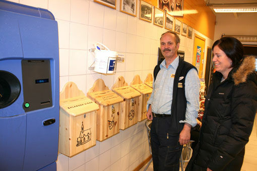 På bildet: Butikksjef Agnar Fossbakk og kirkeverge Tonje Østvik foran postkassene hvor de som vil kan legge pantesedlene. FOTO: OLA KR. GJERTSEN