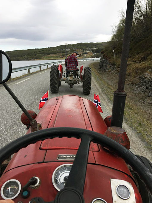 Her kjører Jan Vimme og broren Cato med to gamle traktorer på sørsia av Sagfjorden på en 17.mai.