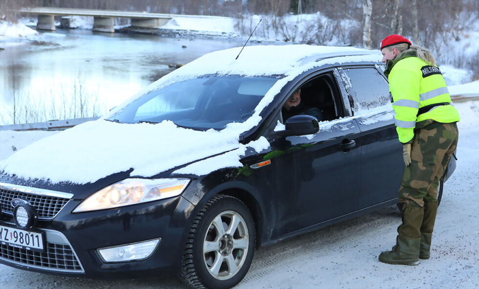 Billistene på veien i Elvelund blir stoppet av de to unge millitærpoliti- soldatene, og får informasjon om at de kjører inn i et unntakstilstand område for store kjøretøyer fra Forsvaret. FOTO: JON HENRIK LARSEN