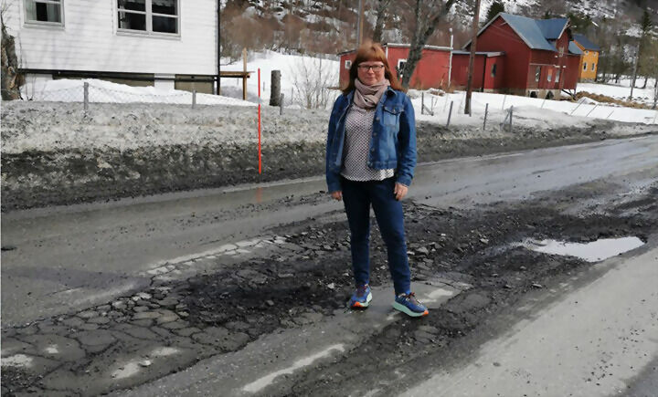 DÅRLIG FORFATNING: Slik ser veien ut per dags dato. Her står Iris Solheim-Nilsen ved de store hullene i veien. FOTO: PRIVAT