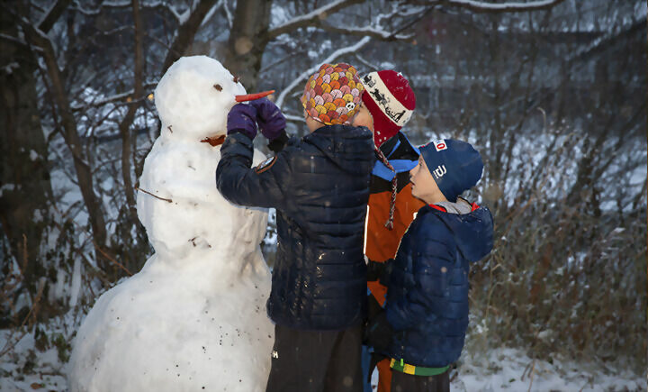 Amanda, Aksel og Christian pynter snømannen .FOTO: MARILEE GOULET